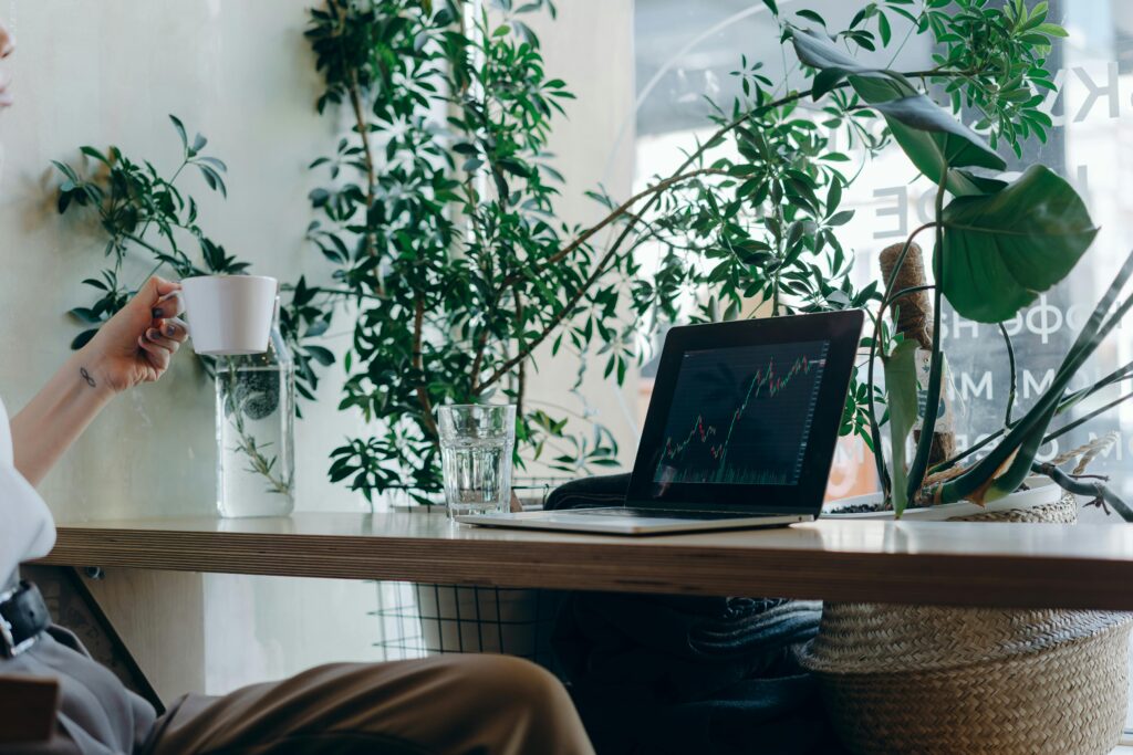 pexels-photo-7681747-7681747 A calm workspace featuring a laptop with graphs, plants, and a coffee cup.